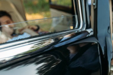 Arabanın içinde yalan ve el ele tutuşarak görünür insanlar pencere araba siyah kapıdan.