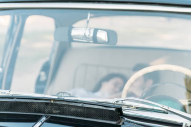 Arabanın içinde yalan ve elele, öpüşme car.people tarih. Arabada pencereden bak. Beyaz direksiyon wheel.summer zaman içinde siyah otomatik cam üzerinden görüntülemek