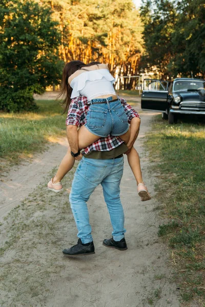 여자는 남자의 Back He에 그녀의 Legs Check 셔츠를 Jeans 배경은 — 스톡 사진