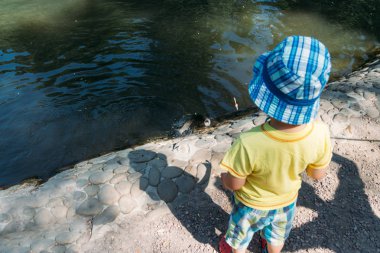 Çocuk sahilde duran ve balık lake.fishing dışarı alınır izliyor