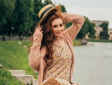 güzel kızıl saçlı girl.picture nehir, su, lake Park, summer.puts kafasına bir şapka arka planı