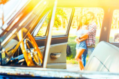 bir görünümü için güzel bir gün kucaklama bir çift üzerine tüm araba ile eski model bir araba yan pencereden. Araba direksiyon, yaz günlerinde, date.watch, spy.stake dışarı