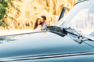 sarılma çift arkasında siyah arabanın kaputu. seyahat, turist