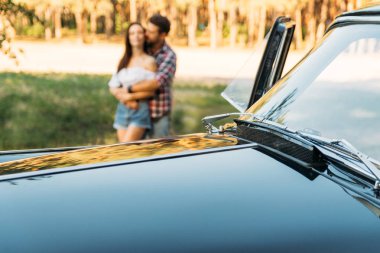 sarılma çift arkasında siyah arabanın kaputu. seyahat, turist