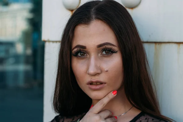 Emotional portrait of Fashion stylish portrait of pretty young woman. city portrait. sad girl. brunette in a black dress with stars and planets on a dress. expectation. dreams