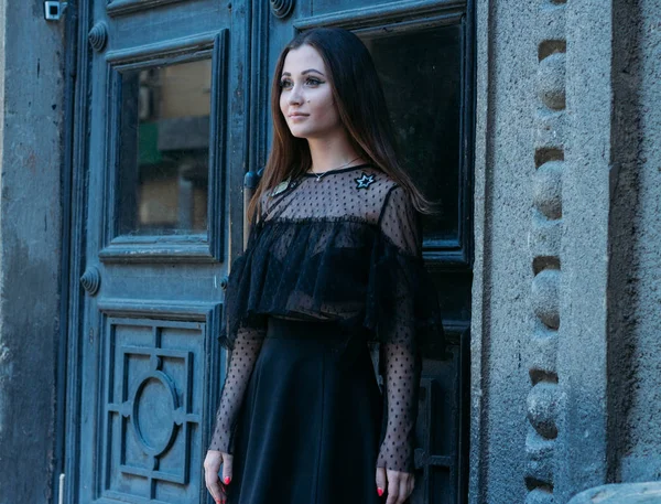 Emotional portrait of Fashion stylish portrait of pretty young woman. city portrait. sad girl. brunette in a black dress with stars and planets on a dress. expectation. dreams.black circles under the eyes, insomnia