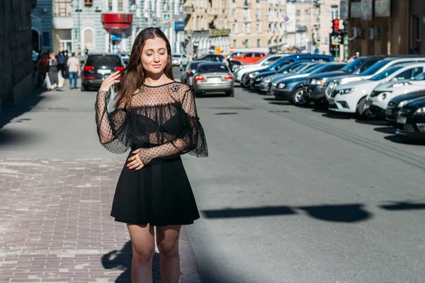 Emotional portrait of Fashion stylish portrait of pretty young woman. city portrait. sad girl. brunette in a black dress with stars and planets on a dress. expectation. dreams.black circles under the eyes, insomnia