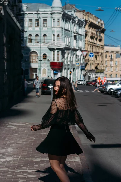 Hermosa morena gira, baila en una calle en el centro de la ciudad, ríe, sonríe, felicidad, diversión —  Fotos de Stock