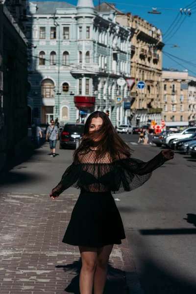 Mooie brunette wervelingen, dansen op een straat in het midden van de stad, lacht, lacht, geluk, plezier — Stockfoto