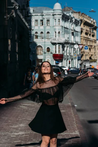 Hermosa morena gira, baila en una calle en el centro de la ciudad, ríe, sonríe, felicidad, diversión —  Fotos de Stock