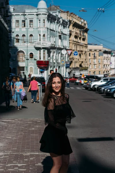 Hermosa morena gira, baila en una calle en el centro de la ciudad, ríe, sonríe, felicidad, diversión —  Fotos de Stock