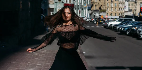 Linda morena gira, dança em uma rua no meio da cidade, ri, sorri, felicidade, diversão — Fotografia de Stock