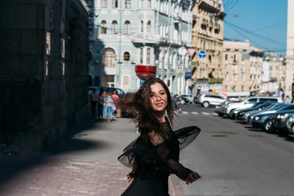 Belle brune tourbillonne, danse dans une rue au milieu de la ville, rit, sourit, bonheur, amusement — Photo