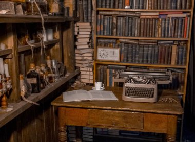 Eski daktilo masaya yanında kitap yatıyor ve kitapların raflarda bir cup.old olduğunu. Araştırmacı, eleştirmen, bilim adamı Vintage Odası,