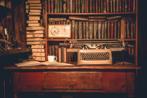 Eski daktilo masaya yanında kitap yatıyor ve kitapların raflarda bir cup.old olduğunu. Araştırmacı, eleştirmen, bilim adamı Vintage Odası,