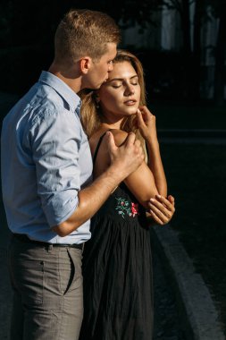 adam öpücük bir kız onu, sarılma, sokaklarda birbirine çekti. siyah bir dress.man kız arkasından kadın hugs ve alnından öper