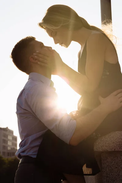 Le couple embrasse, et entre eux les rayons du soleil, le soleil, la lumière. attraction entre un homme et une femme. baiser au soleil. embrasser le soleil. entre nous est le soleil . — Photo