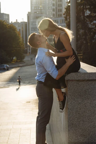 Das Paar küsst sich, und dazwischen die Sonnenstrahlen, die Sonne, das Licht. Anziehung zwischen einem Mann und einer Frau. Kuss in der Sonne. küsst die Sonne. zwischen uns liegt die Sonne. — Stockfoto