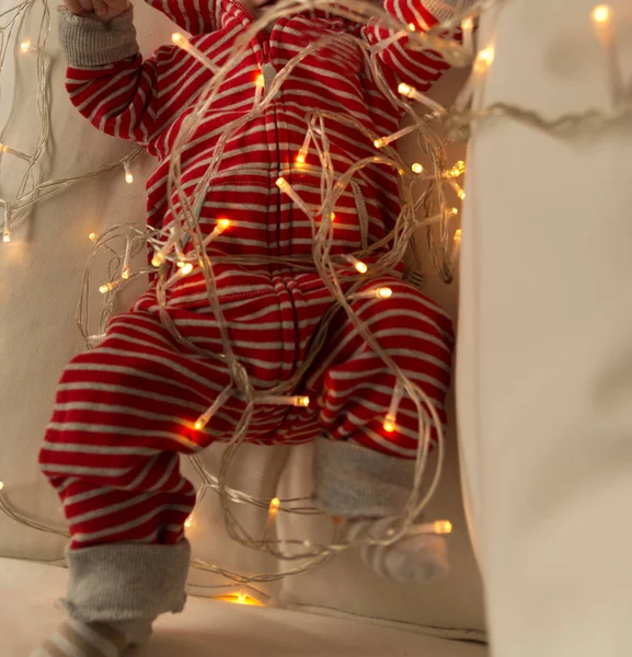 Bebê Terno Listrado Vermelho Deitado Sofá Brincando Com Uma Grinalda — Fotografia de Stock