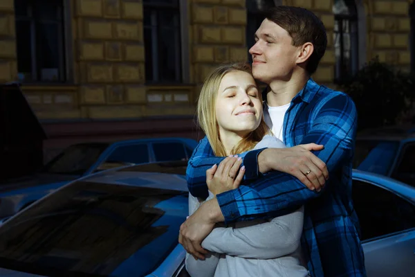 Retrato de um casal feliz abraçando na rua, na cidade.Em pé melhor do sol, luz dura. data — Fotografia de Stock