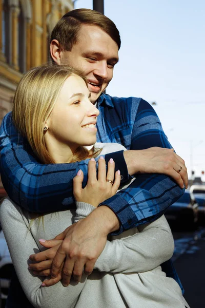 Retrato de um casal feliz abraçando na rua, na cidade.Em pé melhor do sol, luz dura. data — Fotografia de Stock