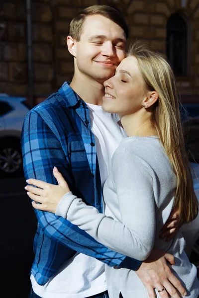 Retrato de um casal feliz abraçando na rua, na cidade.Em pé melhor do sol, luz dura. data — Fotografia de Stock