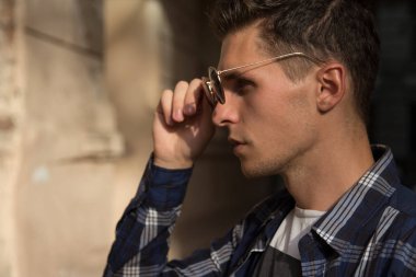 nerede o gözlük tutan, onun güneş gözlükleri, Erkek portre profil, kapalı alır bir adam Close-up gözlük yakın atış gencin ülke zammı üzerinde dokunur. Sunglasses.Buying gözlüklü beyaz erkek modeli