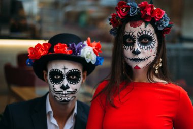 Bir çift, kafatası makyaj için. Bütün ruhlar gün. Erkek ve kız şeker kafatası makeup.painted Cadılar Bayramı için bir kafede oturmak. şehirde öldü. Meksika'da ölü tatil zombi walk.day