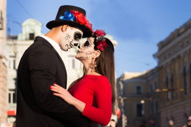 Bir çift, kafatası makyaj için. Bütün ruhlar gün. Erkek ve kız şeker kafatası makeup.painted Cadılar Bayramı ayakta sokakta için. şehirde öldü. Meksika'da ölü tatil zombi walk.day