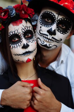 Bir çift, kafatası makyaj için. Bütün ruhlar gün. Erkek ve kız şeker kafatası makeup.painted Cadılar Bayramı ayakta sokakta için. şehirde öldü. Meksika'da ölü tatil zombi walk.day