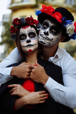 Bir çift, kafatası makyaj için. Bütün ruhlar gün. Erkek ve kız şeker kafatası makeup.painted Cadılar Bayramı ayakta sokakta için. şehirde öldü. Meksika'da ölü tatil zombi walk.day