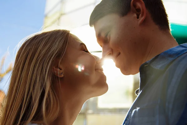 一对幸福的夫妇拥抱在街上 在城市的肖像 站在更好的从太阳 太阳照耀在脸上 在一个男人和一个女人之间的太阳光线 一个吻 — 图库照片