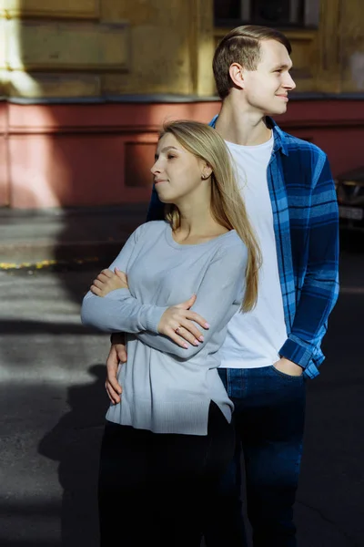 Portret szczęśliwa para, przytulanie na ulicy, w city.standing w lepszy od słońca, Ostre światło. Date.The słońce świeci na twarzach, promienie słońca między mężczyzną i kobietą, pocałunek — Zdjęcie stockowe