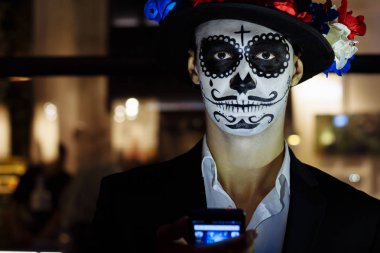 bir iskelet, ölü bir zombi, gün boyunca şehirde boyalı yüzü olan bir adam. gün tüm ruhların, ölüler günü ', Cadılar Bayramı, hayalet yürüyüş şapka içinde