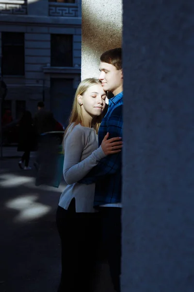 Portret van een gelukkige paar knuffelen in de straat, in de city.standing beter uit de zon, fel licht. date.The zon schijnt op de gezichten, de stralen van de zon tussen een man en een vrouw, een kus — Stockfoto