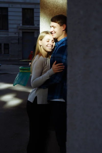 Portrét šťastnému páru objímání na ulici, v city.standing v lepší od sun.date.the slunce svítí na tvářích, pár tváří na slunci — Stock fotografie