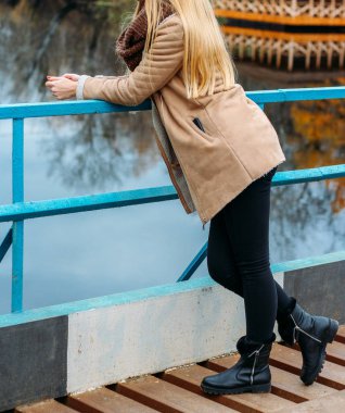 Kız nehir ve kahverengi bir eşarp, snod yakınındaki bir kahverengi ceketli. Sonbahar, örme işleri, el yapımı,