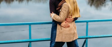 Köprüde suya yakın çift kucaklayan sonbahar. aşk ve Aile, nehrin kenarında parkta bir tarih