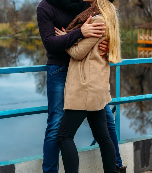 Пара обнимается на мосту, у воды, осенью. любовь и семья, свидание в парке у реки — стоковое фото