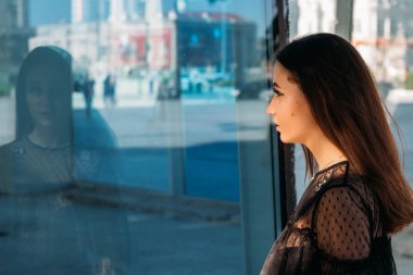 Cam yansıması. Genç ve güzel kadın moda şık portresi duygusal portresi. Şehir portre. üzgün kız. yıldızlar ve gezegenler bir elbise ile siyah bir elbise esmer. beklenti. rüyalar