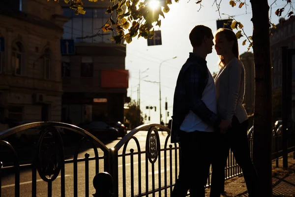 Pasangan bahagia berpelukan, berciuman di jalan di kota. Kencan. kita sendirian di dunia. terhadap matahari, siluet gelap — Stok Foto