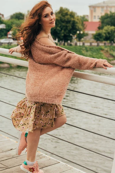 드레스와 따뜻한 색상의 스웨터를 도시에 낭만적인 그녀의 머리는 바람에 현기증 — 스톡 사진