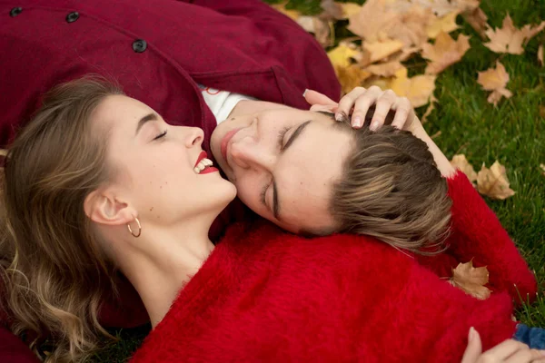 Sorrindo Casal Deitado Grama Close Uma Menina Cara Camisolas Vermelhas — Fotografia de Stock