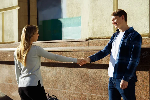 Glückliches, lächelndes Paar, ein Mädchen hält die Hand eines Typen und ruft nach ihm, zieht, führt. — Stockfoto