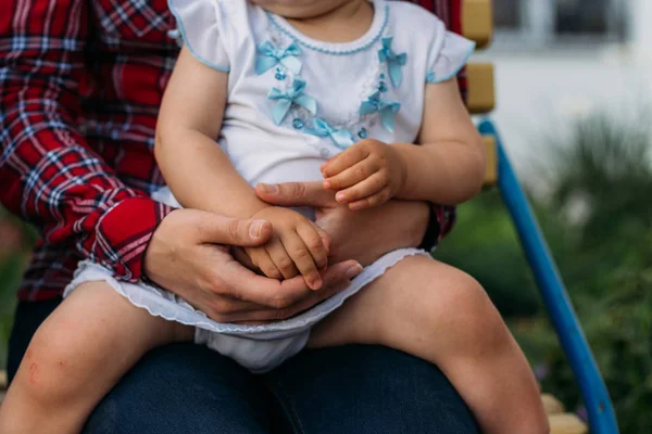 A little girl sits in the arms of a girl, she is hugged behind her back and holding hands. — Stock Photo, Image