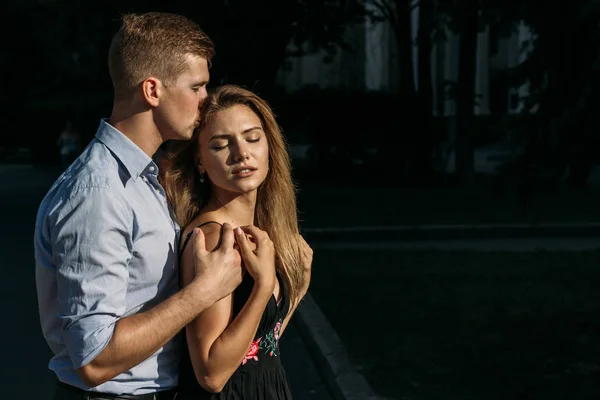 black background. happy, loving couple hugging. boyfriend kissing girl and hugging from behind, protection.protects. smiles