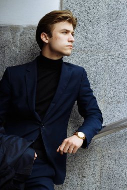 Mavi bir takım elbise, ceket, kentin yakışıklı, çekici, Genç bir adam portresi. dalgın ve üzgün, bekliyor. iş adamı. yandan izle