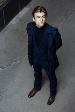 Mavi bir takım elbise, ceket, kentin yakışıklı, çekici, Genç bir adam portresi. dalgın ve üzgün, bekliyor. iş adamı. yandan izle