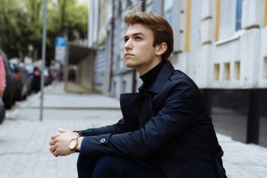 Mavi bir takım elbise, ceket, kentin yakışıklı, çekici, Genç bir adam portresi. dalgın ve üzgün, bekliyor. iş adamı