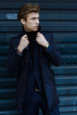 Mavi bir takım elbise, ceket, kentin yakışıklı, çekici, Genç bir adam portresi. dalgın ve üzgün, bekliyor. iş adamı. yandan izle